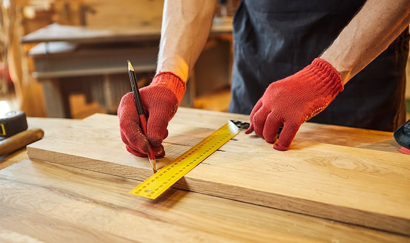 carpenter measuring wood for a project