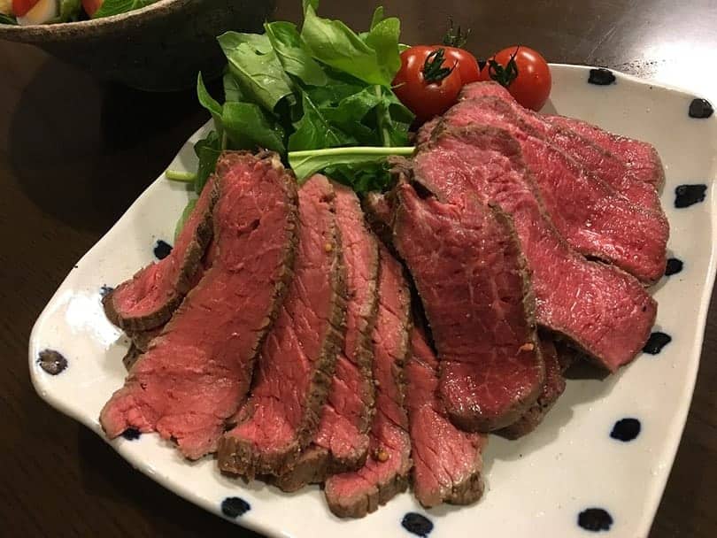 wagyu beef with spinach and tomatoes on a plate